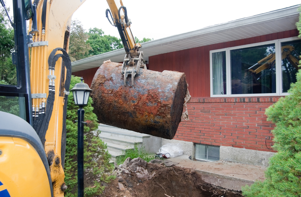 old rusted oil tank being removed from ground